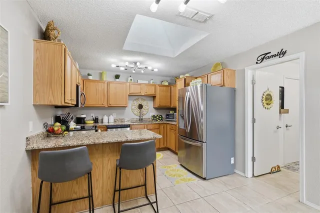 a kitchen with kitchen island granite countertop a sink cabinets and stainless steel appliances