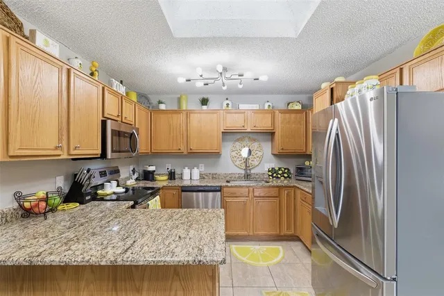 a kitchen with a refrigerator sink and cabinets