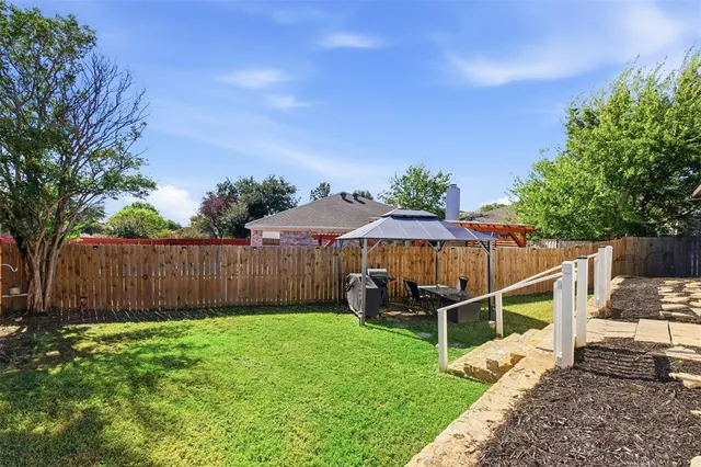a backyard of a house with table and chairs