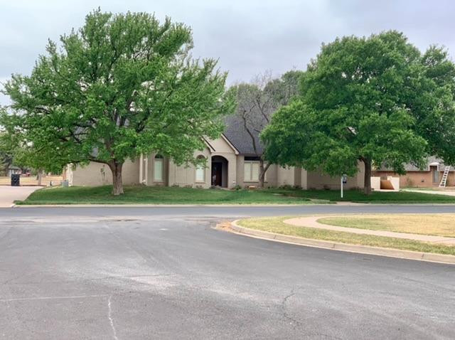 a view of a house with a big yard and large trees