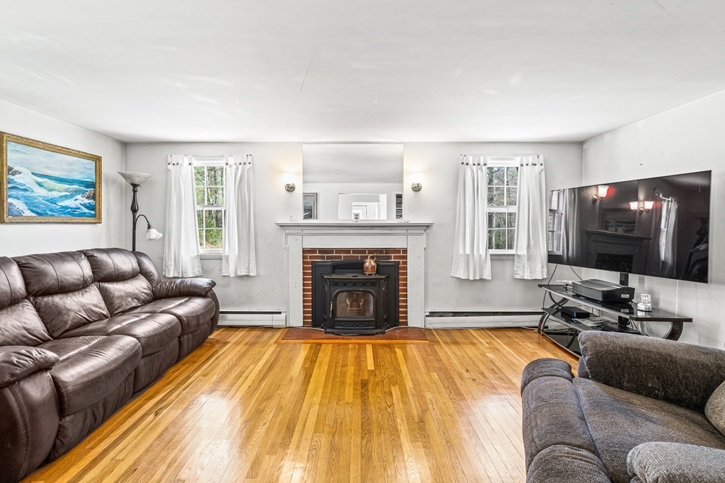 89 Willow Road Boxford, MA 01921 - Photo 5 of 22 a living room with a couch a rug and a flat screen tv