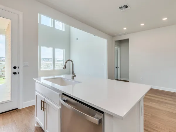 a kitchen with a sink cabinets and wooden floor