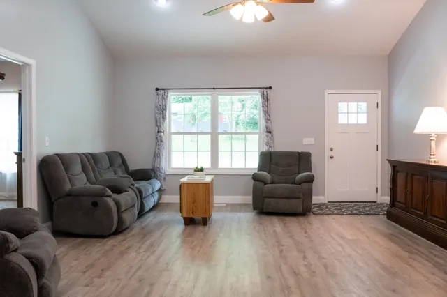 a dining room with furniture a chandelier and wooden floor