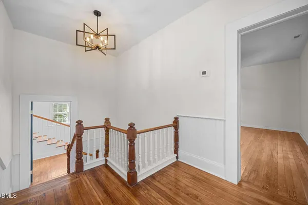 a view of a hallway with wooden floor and staircase