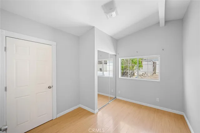 a view of an empty room with window and closet area