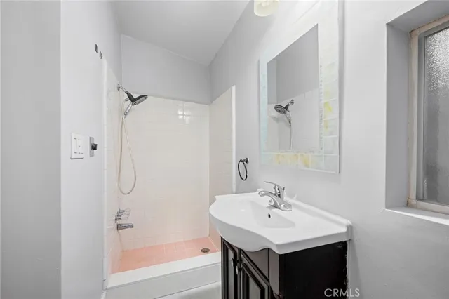 a bathroom with a sink a shower and a mirror