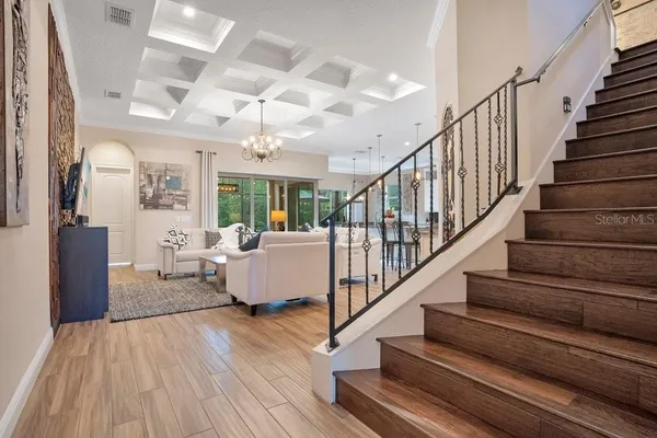 a living room with furniture a chandelier and a large window