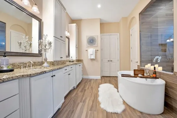 a bedroom with a bed a dresser and windows