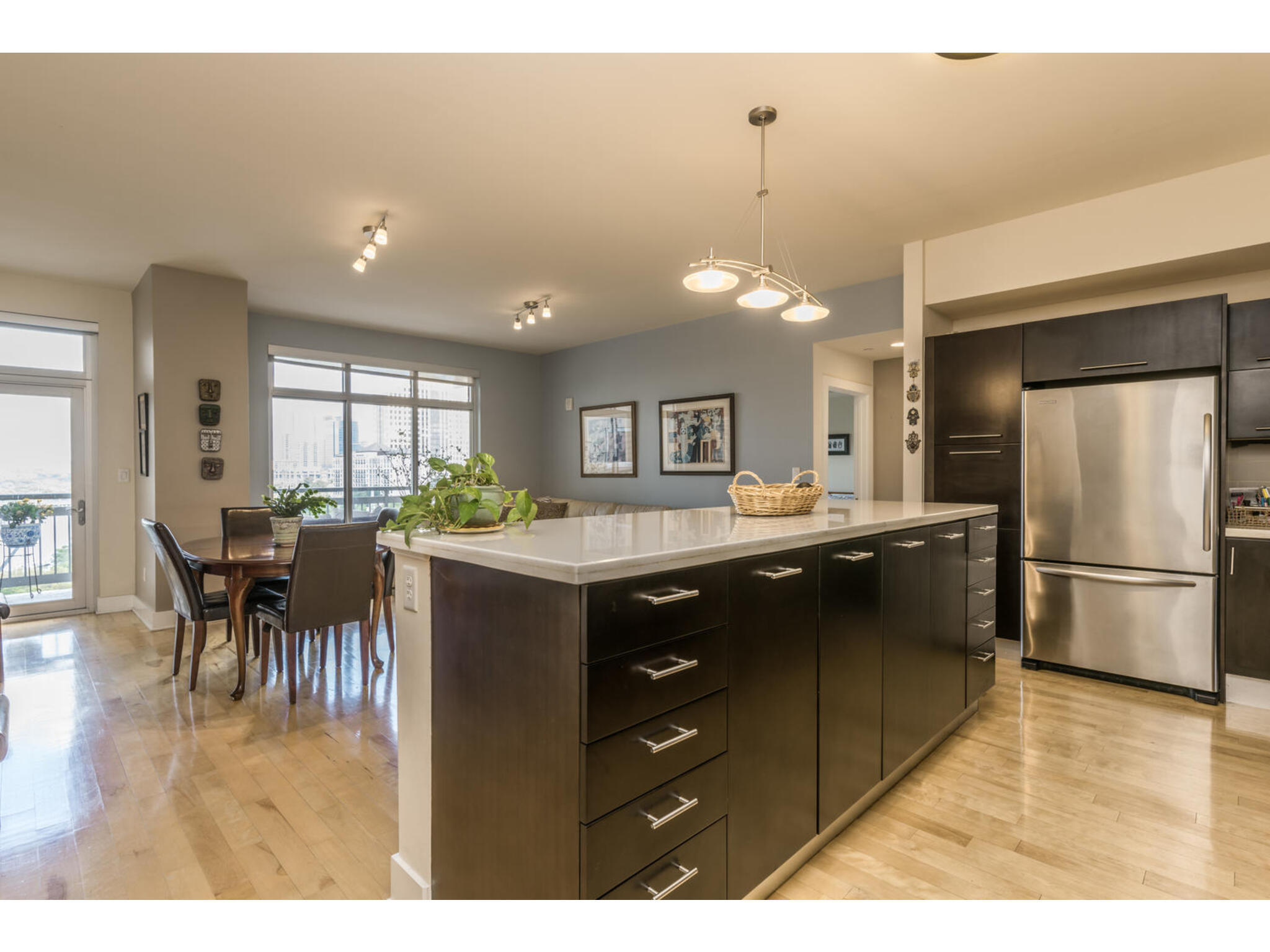 603 Davis Street, Unit 902 Austin, TX 78701 - Photo 1 of 21 Kitchen with a kitchen island, freestanding refrigerator, light wood-style flooring, and decorative light fixtures