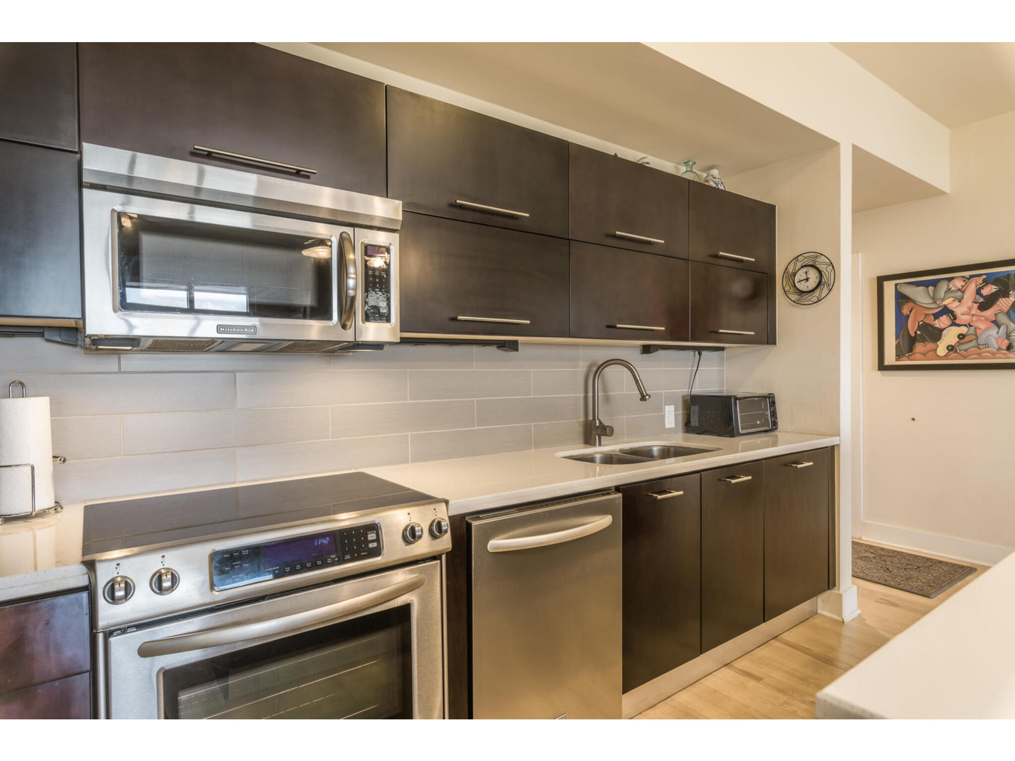 603 Davis Street, Unit 902 Austin, TX 78701 - Photo 12 of 21 Kitchen with stainless steel appliances, dark wood finish cabinets, and modern cabinets