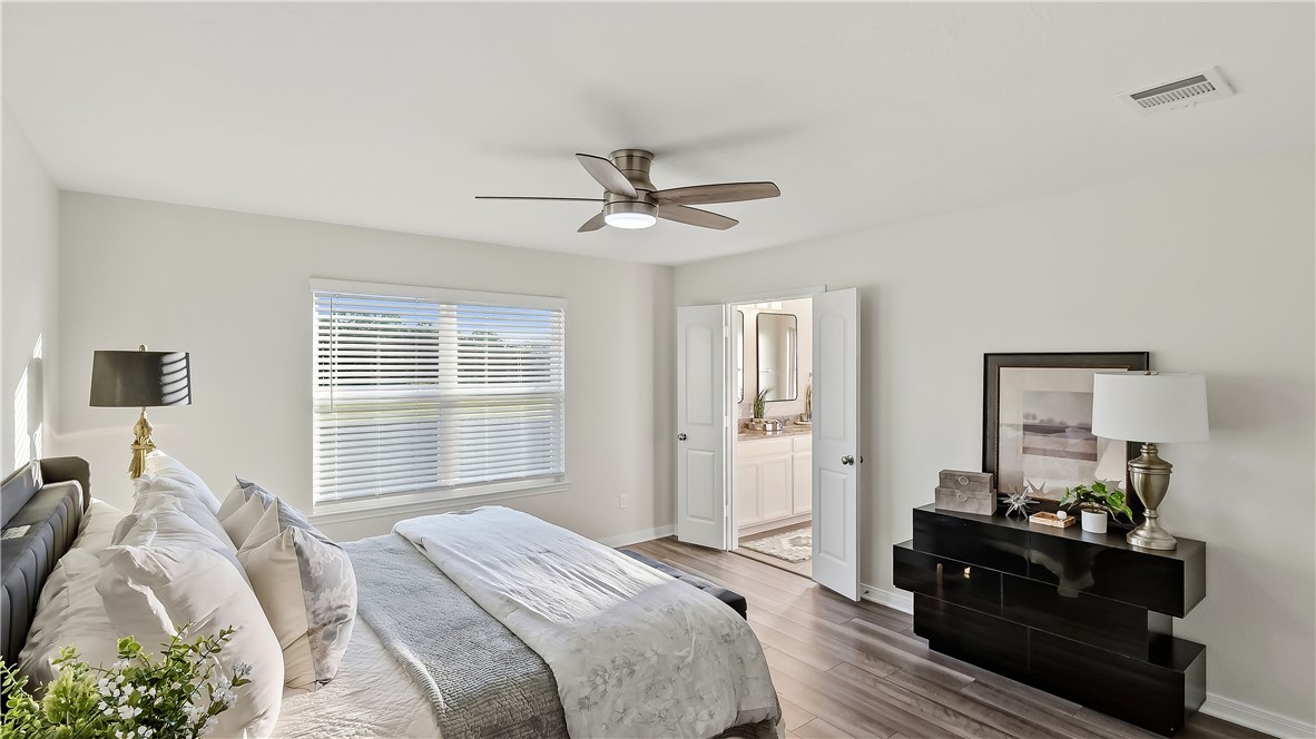 2707 Redcap Street Bryan, TX 77803 - Photo 16 of 28 Spacious bedroom featuring wood-finish flooring, a ceiling fan with integrated lighting, and a window with horizontal blinds