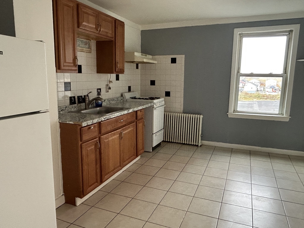 332 Revere Beach Boulevard, Unit 7 Revere, MA 02151 - Photo 2 of 8 a kitchen with stainless steel appliances granite countertop a sink stove and cabinets