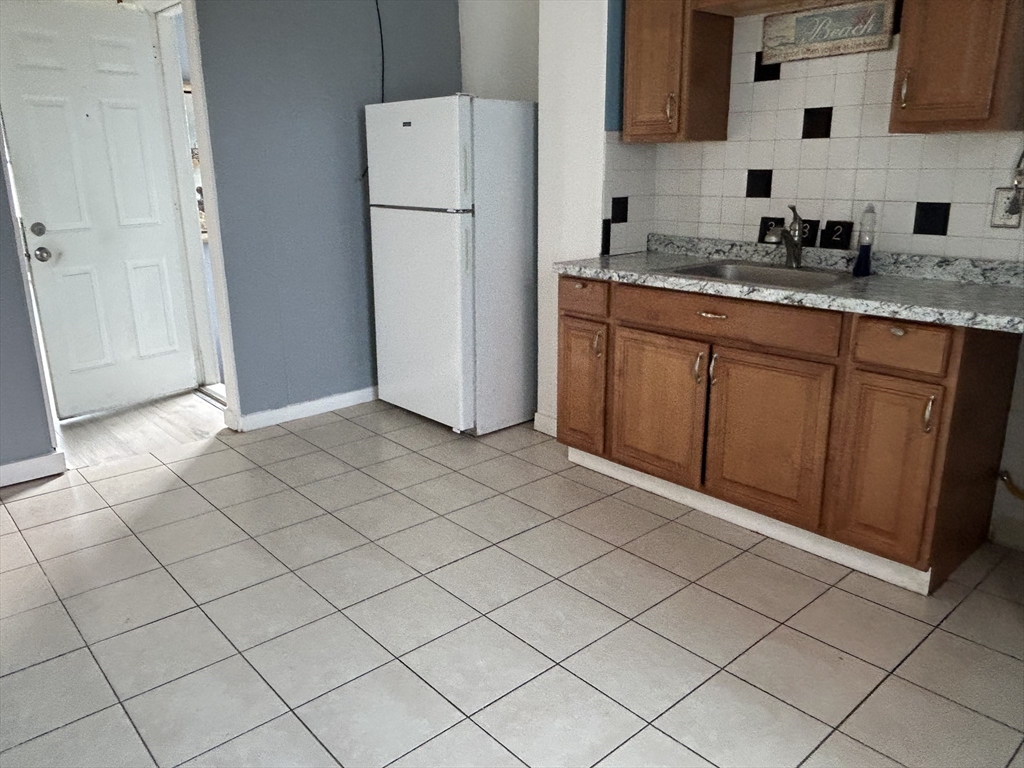332 Revere Beach Boulevard, Unit 7 Revere, MA 02151 - Photo 3 of 8 a kitchen with a sink a refrigerator and cabinets