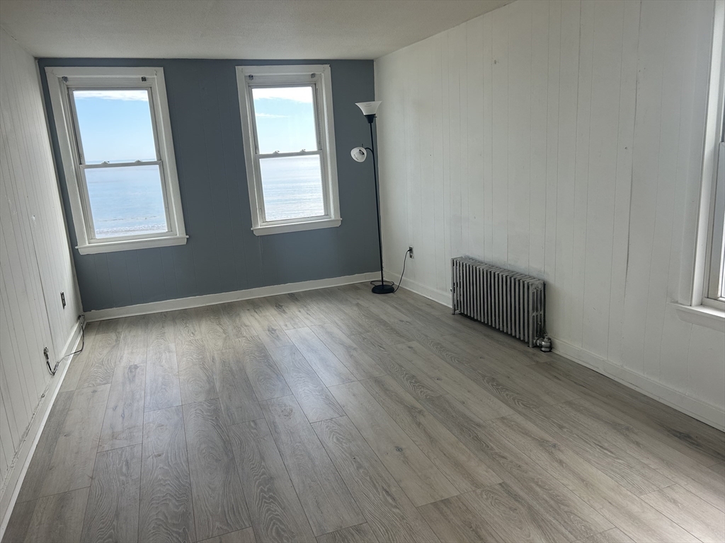 332 Revere Beach Boulevard, Unit 7 Revere, MA 02151 - Photo 4 of 8 an empty room with wooden floor and windows