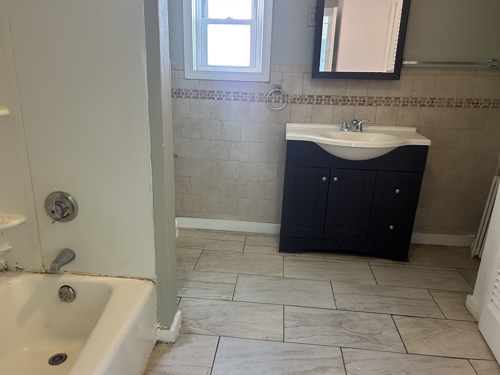 332 Revere Beach Boulevard, Unit 7 Revere, MA 02151 - Photo 8 of 8 a bathroom with a bathtub sink and mirror