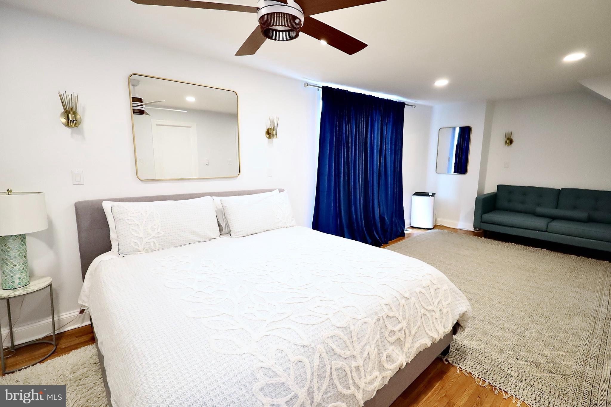 701 Lombard Street Philadelphia, PA 19147 - Photo 14 of 59 a spacious bedroom with a bed and a chandelier