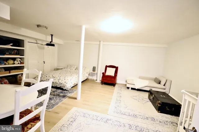 a living room with a bed furniture and a flat screen tv