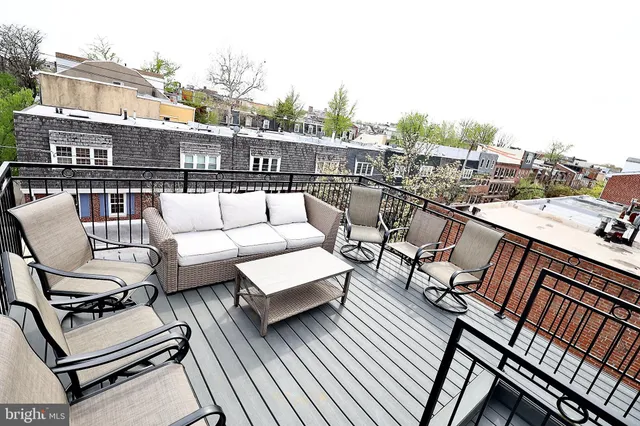 a balcony with wooden floor table and chairs
