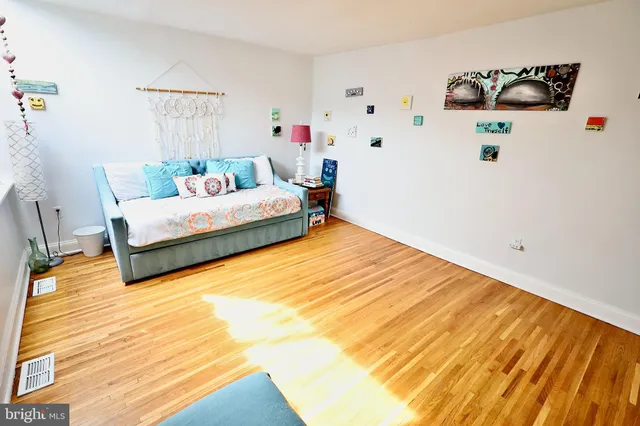a bedroom with a bed painting on the wall and a rug