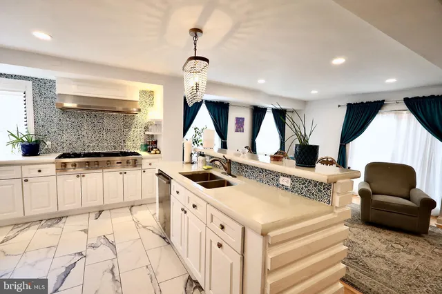 a kitchen with stainless steel appliances kitchen island granite countertop a stove and a sink