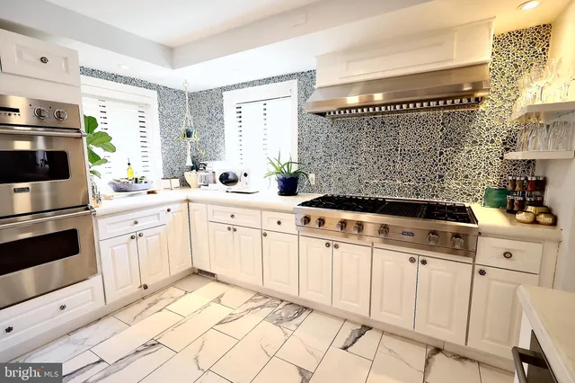 a kitchen with white cabinets and white appliances