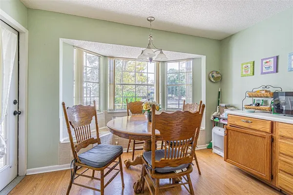 a dining room with furniture a chandelier and wooden floor