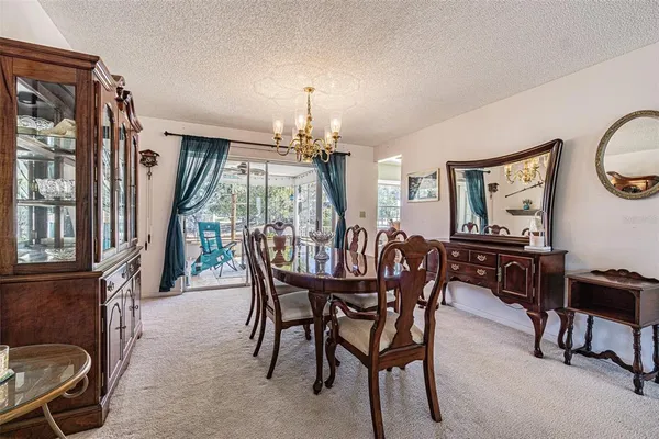a view of a dining room with furniture and a chandelier