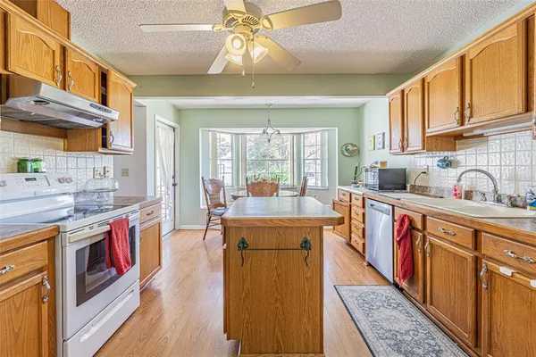 a open kitchen with stainless steel appliances granite countertop a stove and cabinets