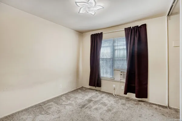 an empty room with windows and closet