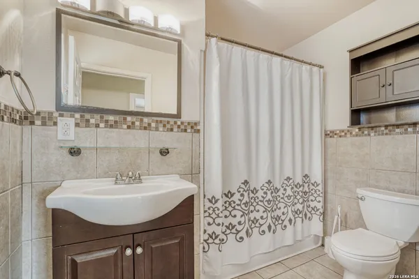 a bathroom with a sink a toilet and a mirror