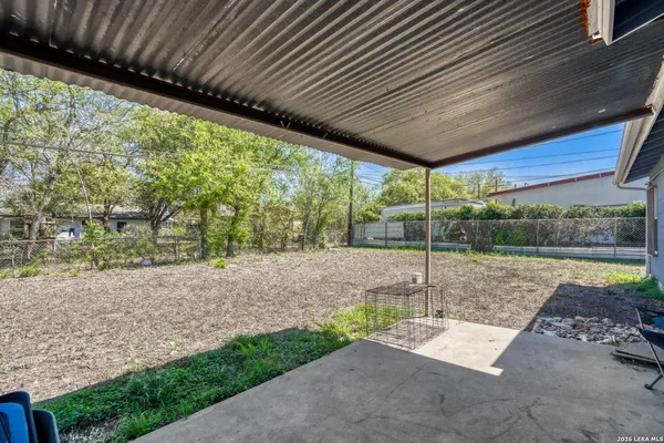 a view of a backyard with table and chairs under an umbrella