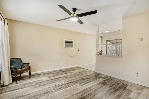 a view of a livingroom with wooden floor and a ceiling fan