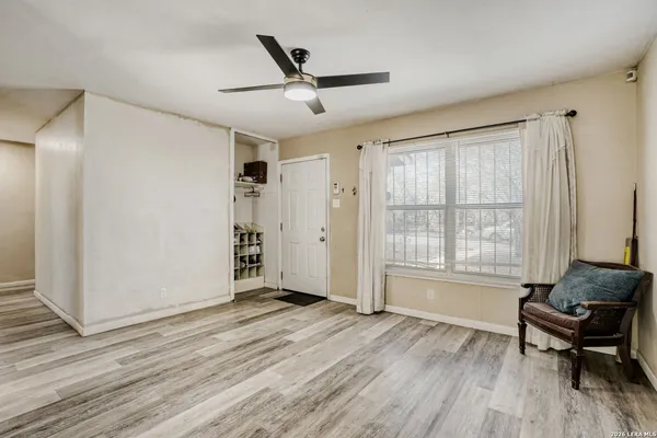 a living room with wooden floor and a window