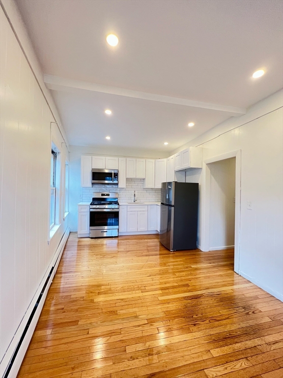 11 Franklin Street, Unit 3 Boston, MA 02129 - Photo 3 of 19 a view of kitchen with kitchen island microwave and stove top oven