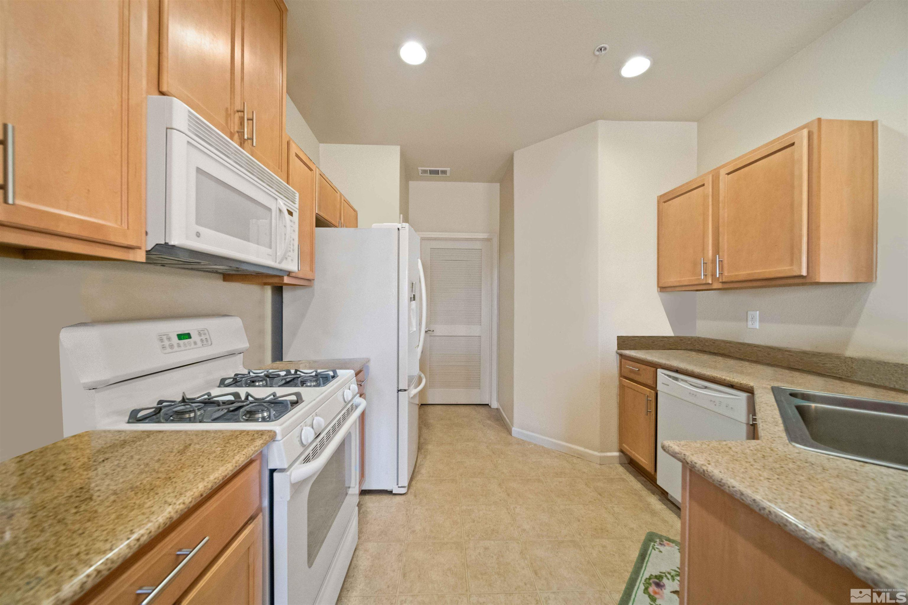 17000 Wedge Parkway Reno, NV 89511 - Photo 11 of 35 a kitchen with stainless steel appliances granite countertop a sink stove and refrigerator