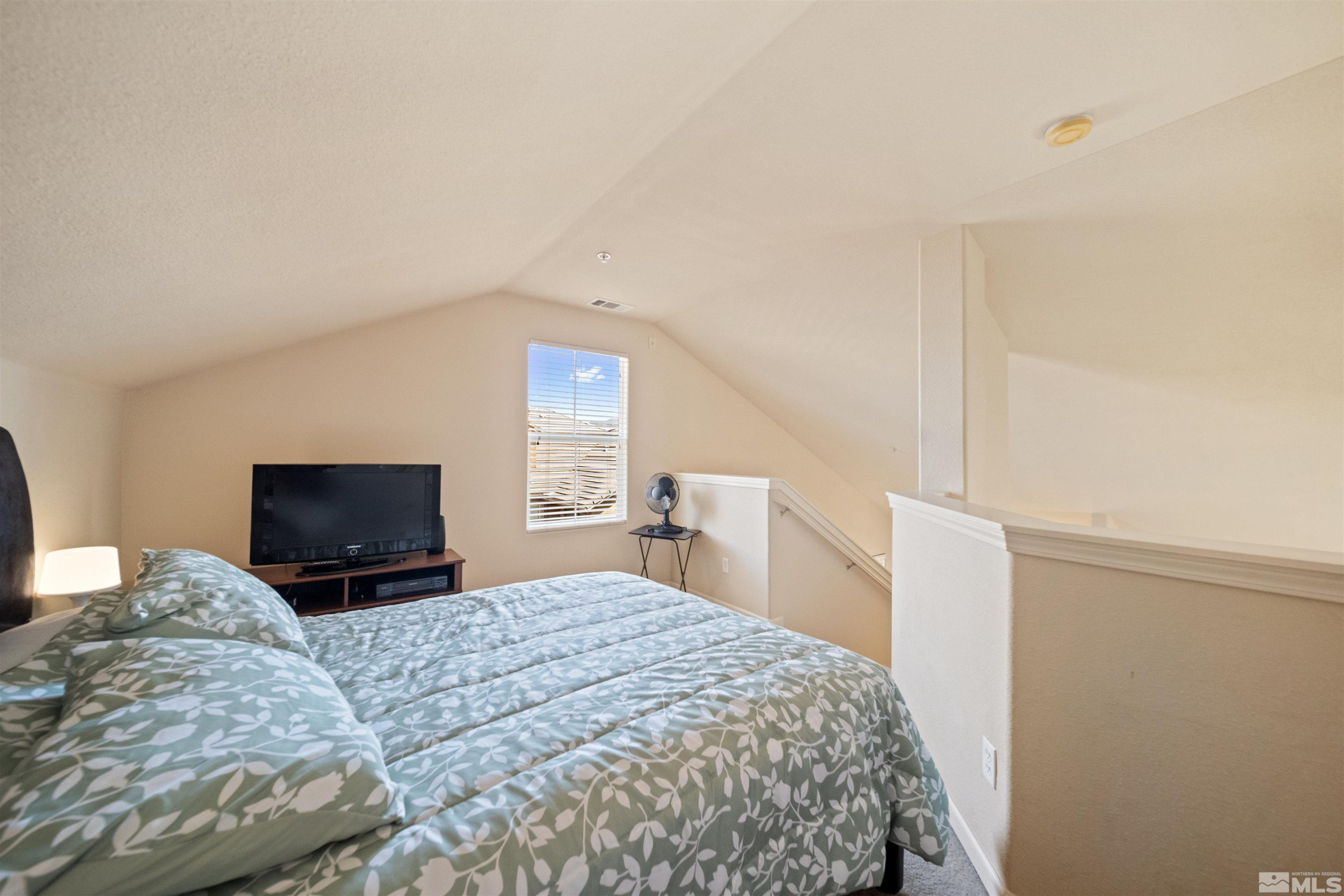 17000 Wedge Parkway Reno, NV 89511 - Photo 14 of 35 a bedroom with a large bed and a tv