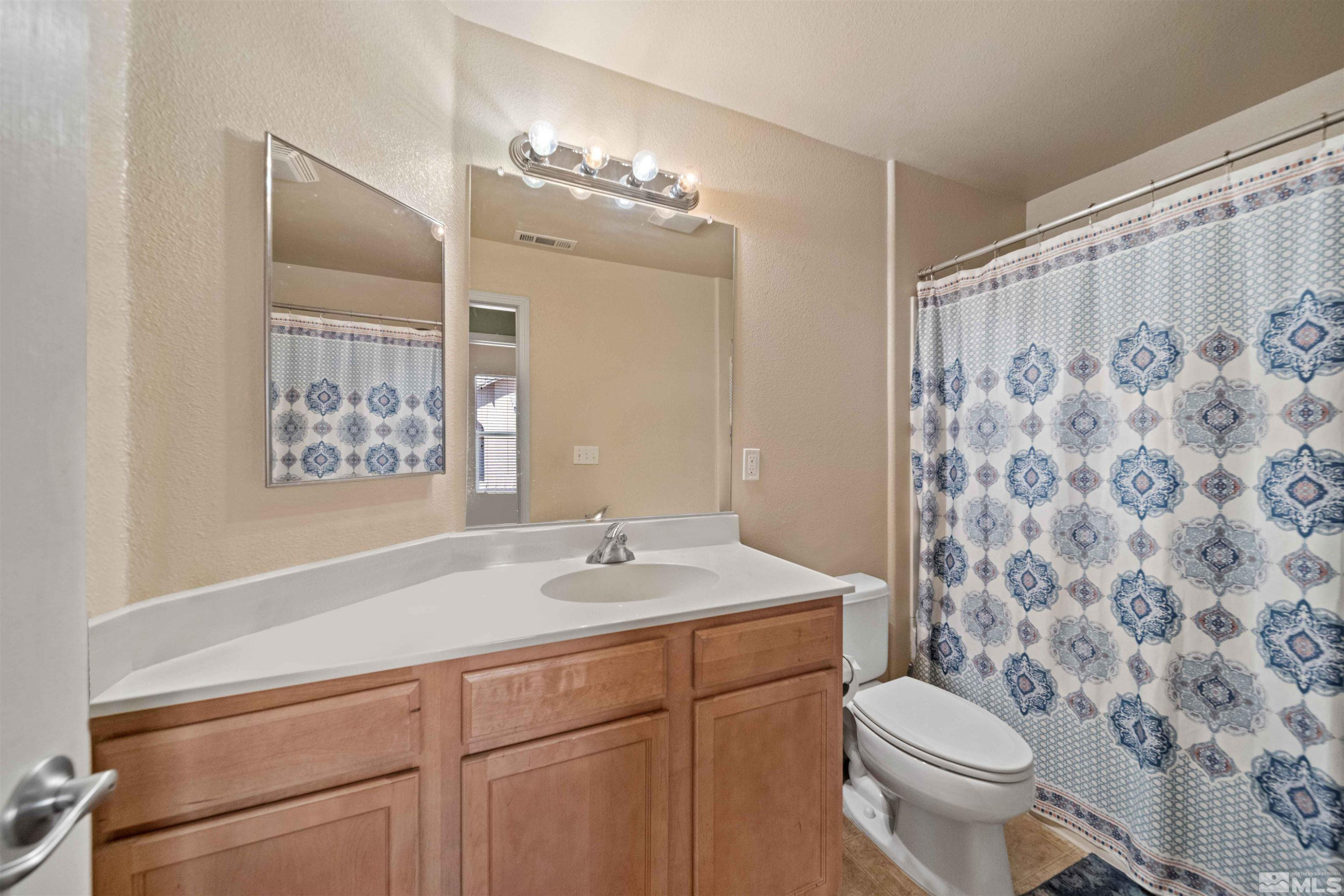 17000 Wedge Parkway Reno, NV 89511 - Photo 22 of 35 a bathroom with a sink a toilet and shower curtain