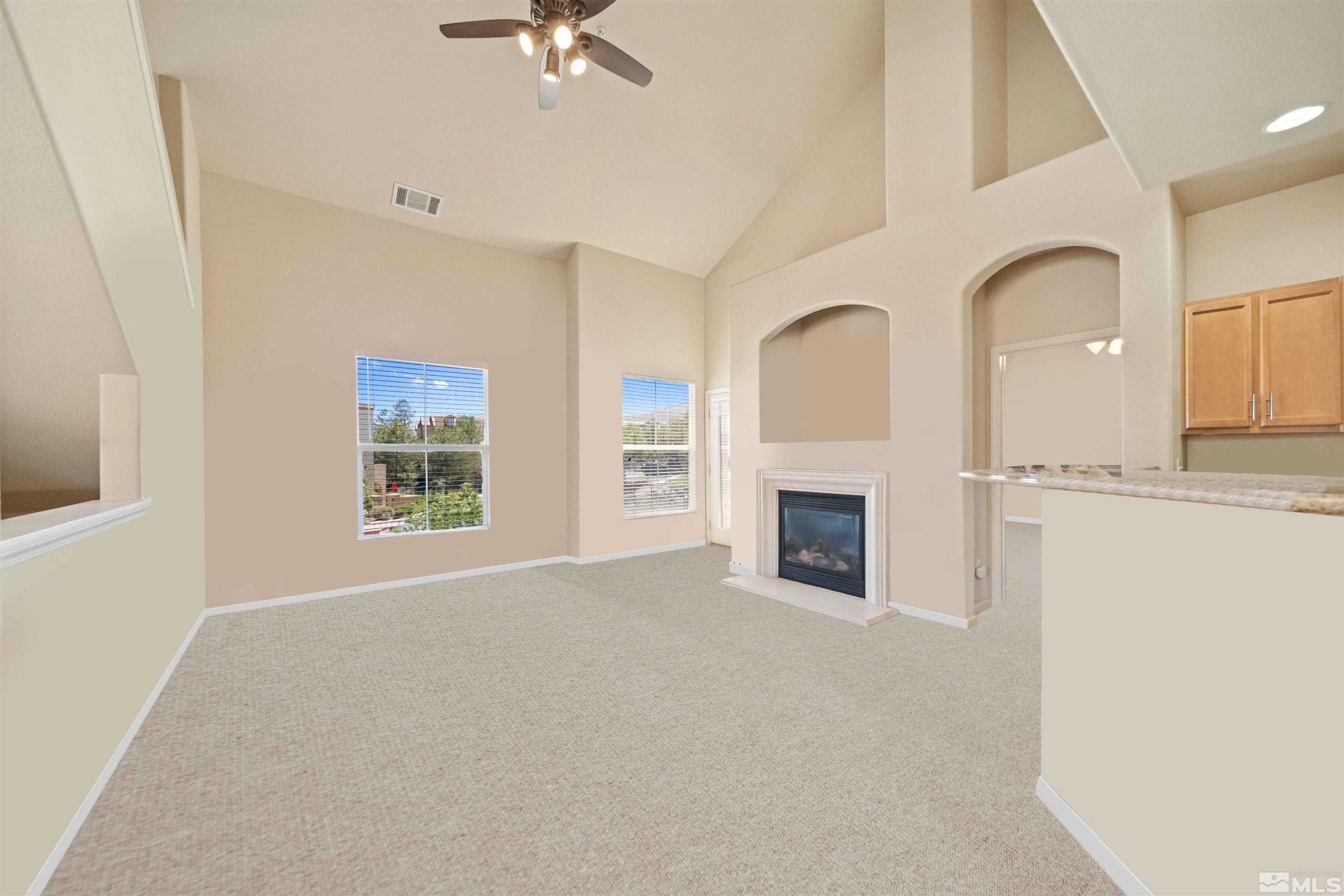 17000 Wedge Parkway Reno, NV 89511 - Photo 5 of 35 a view of a livingroom with a fireplace a ceiling fan and windows