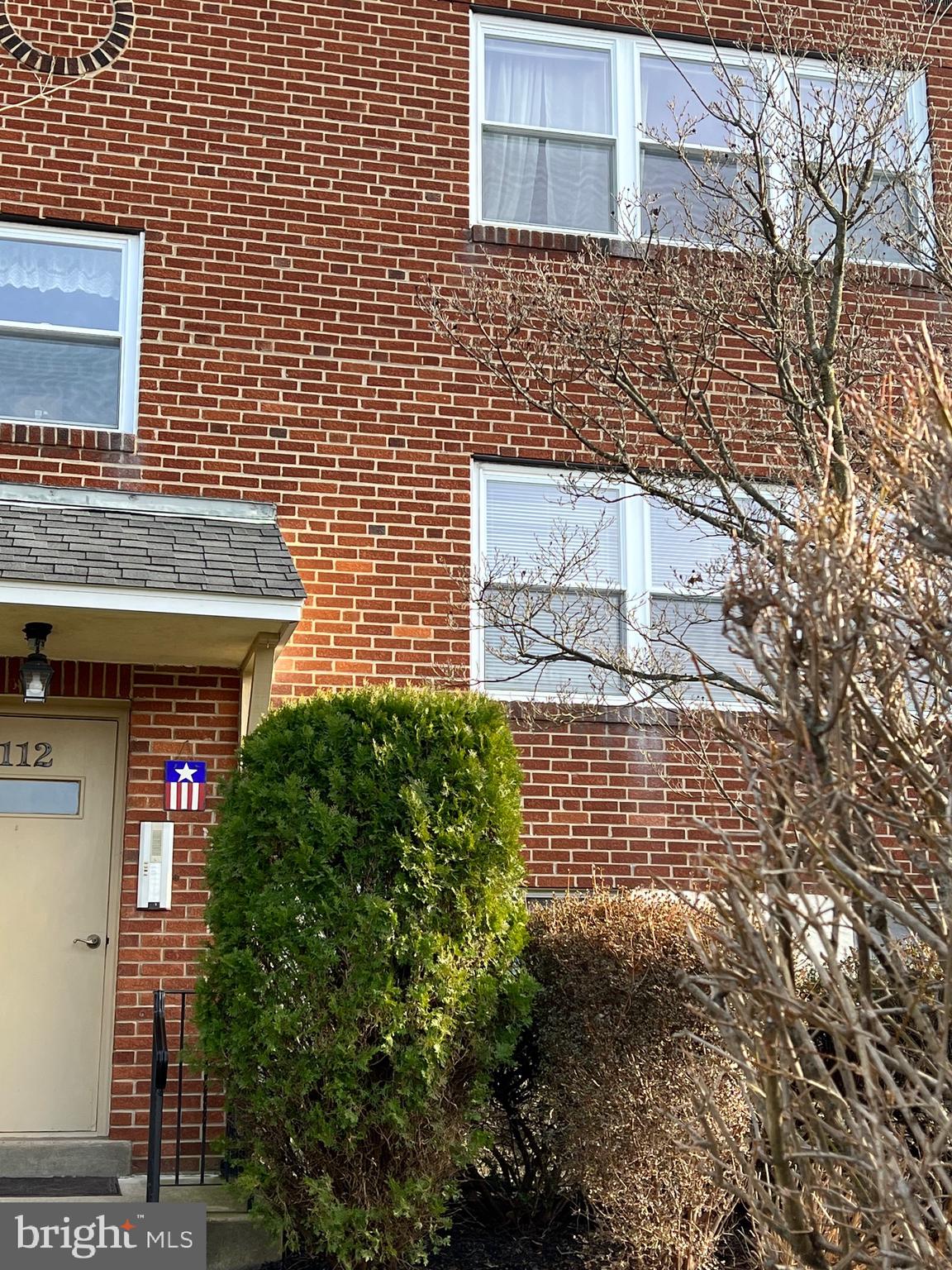 112 Clement Road, Unit B Oreland, PA 19075 - Photo 2 of 19 a view of a brick house with a small yard