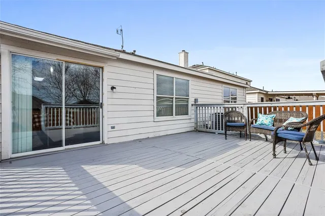 a balcony with wooden floor table and chairs