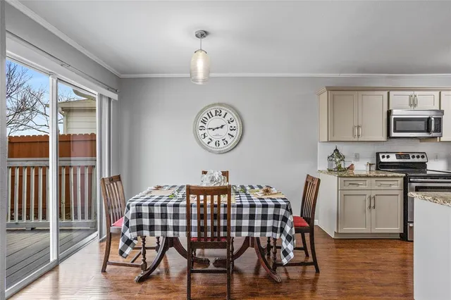 a view of a dining room with furniture a kitchen and chandelier