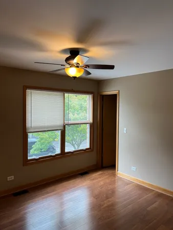 an empty room with a window and wooden floor