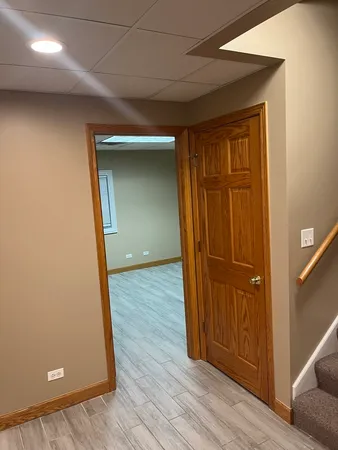 an empty room with wooden floor and cabinet