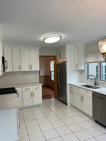 a kitchen with stainless steel appliances granite countertop a refrigerator and a stove top oven