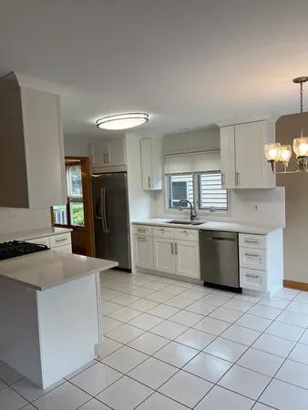 a kitchen with stainless steel appliances kitchen island granite countertop a refrigerator and a stove top oven