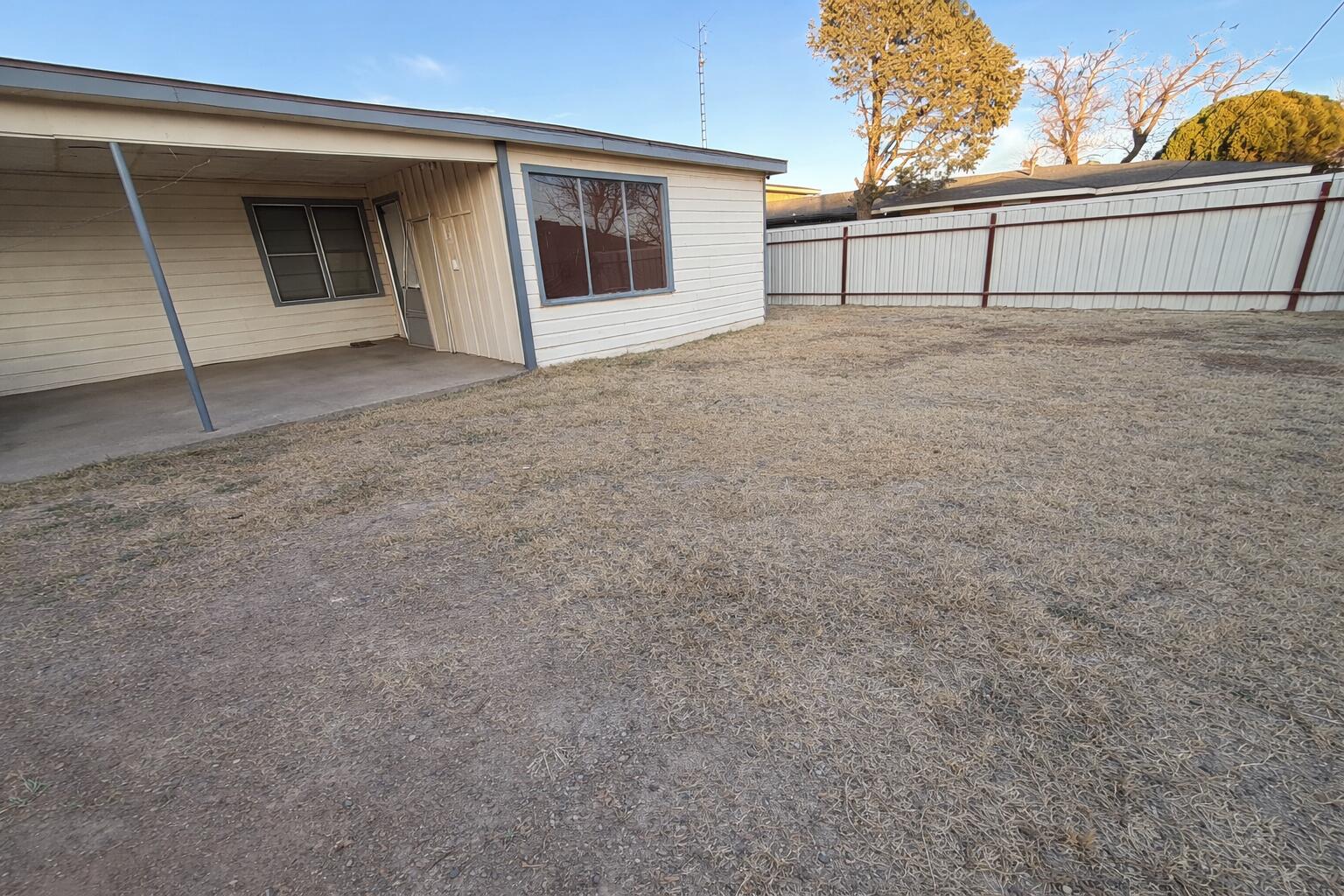 1705 West 16th Street Plainview, TX 79072 - Photo 13 of 13 a view of a house with backyard and trees in the background