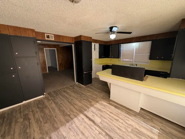 a kitchen with stainless steel appliances kitchen island a refrigerator sink and cabinets