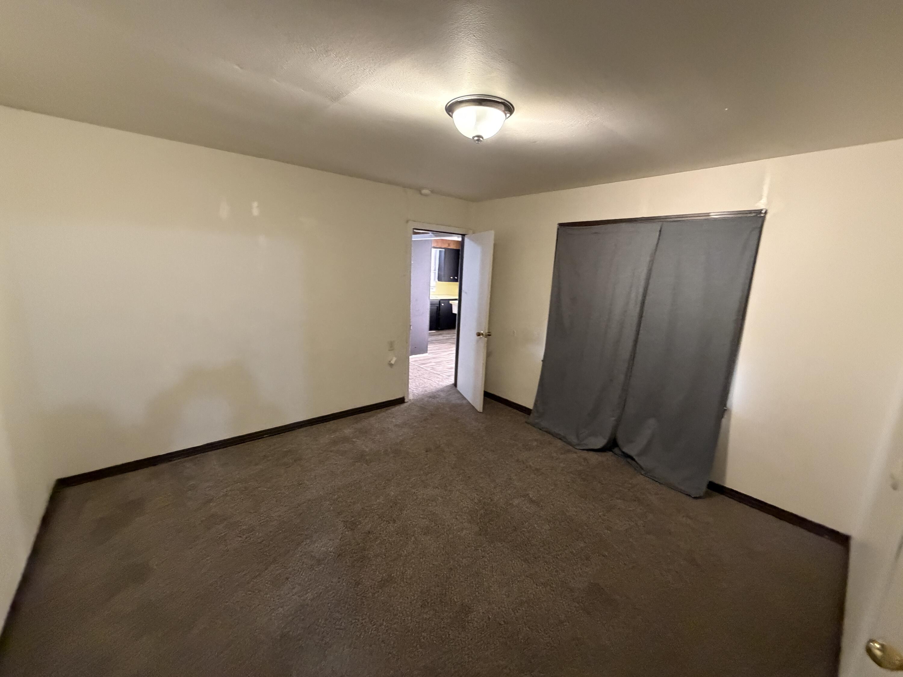 1705 West 16th Street Plainview, TX 79072 - Photo 6 of 13 an empty room with closet and windows