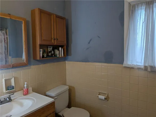 a bathroom with a toilet a sink and mirror