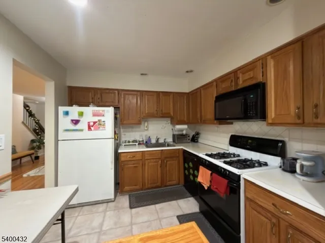 a kitchen with stainless steel appliances a stove a sink a refrigerator a microwave and cabinets